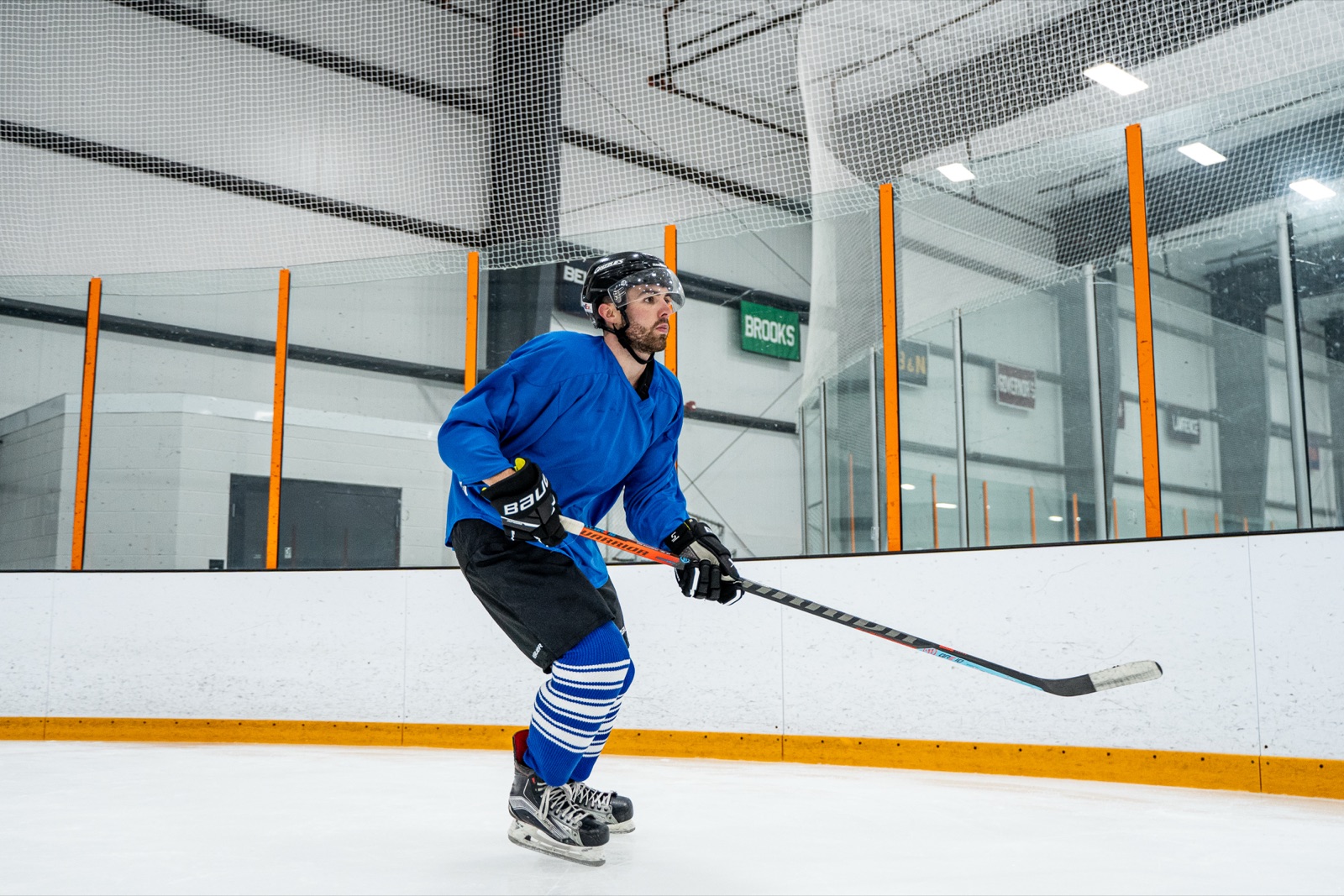 A hockey player skating in a royal blue jersey and Pro Weight knit hockey socks